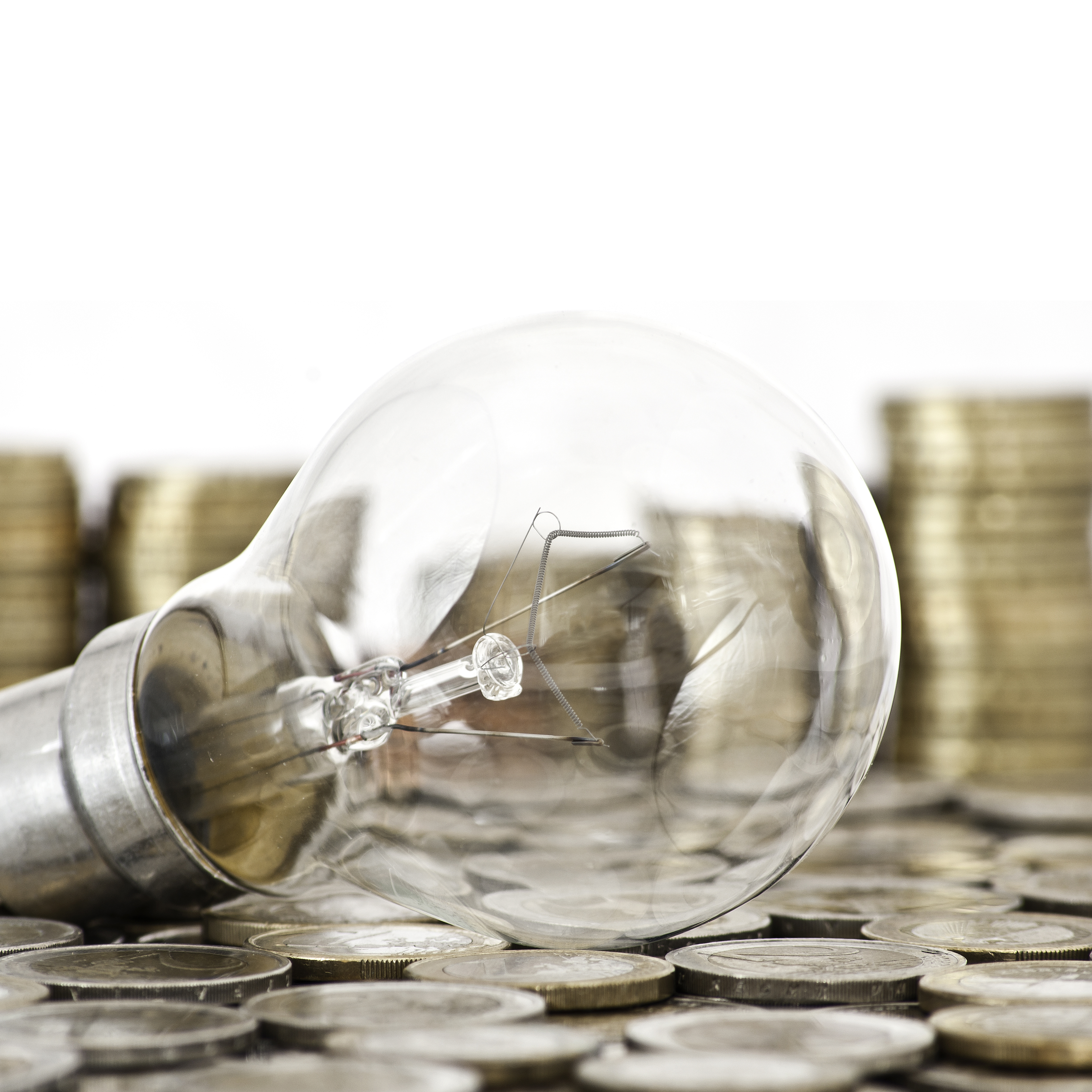 filament bulb lying on euro coins